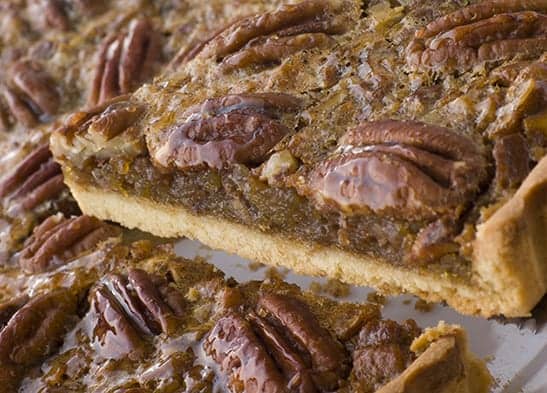 Pecan Pie With A Slice Being Cut