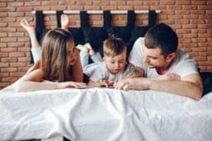 family sitting in a bed 9AEN5DG Family sitting in a bed