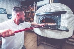 bearded man chef preparing pizza at local PZV8SMF Commercial Pest Control