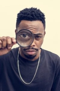 african man playing with a magnifying glass African man playing with a magnifying glass