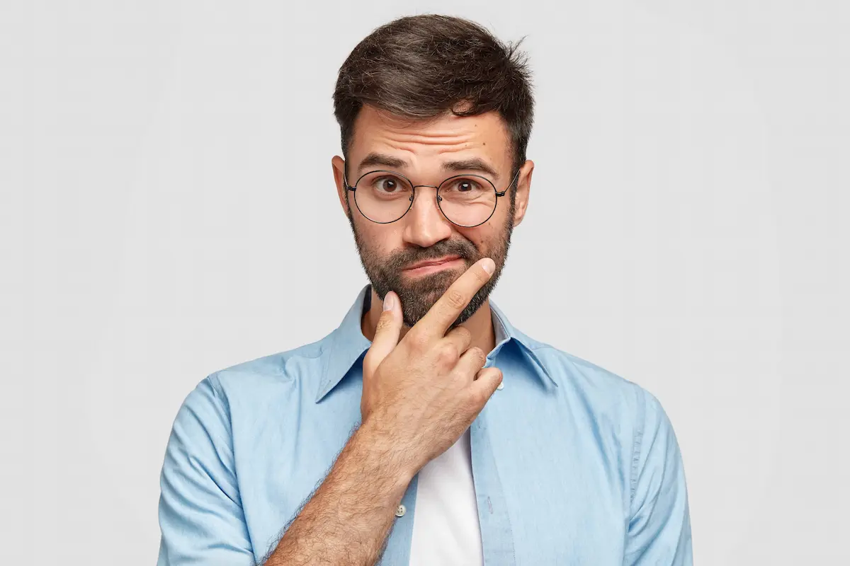 Confused man with glasses making a doubtful facial expression