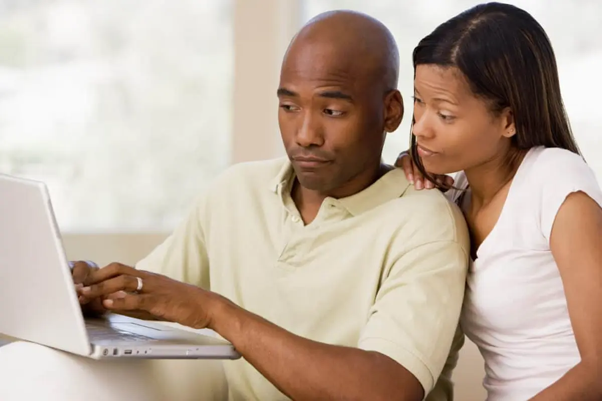 Concerned couple looking at a laptop while researching information about a possible pest issue
