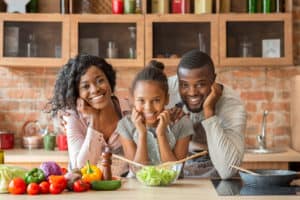 shutterstock 1549745246 Adorable,Afro,Family,Cooking,Healthy,Dinner,Together,At,Kitchen,,Posing