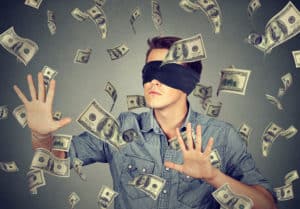 shutterstock 495775999 Blindfolded,Young,Businessman,Trying,To,Catch,Dollar,Bills,Banknotes,Flying