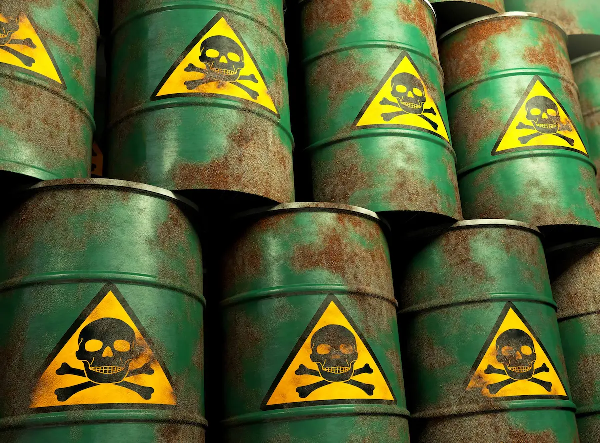 Rusty toxic chemical waste barrels with skull hazard warning signs
