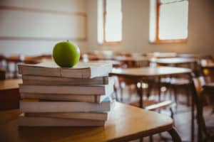 shutterstock 261643652 Apple,On,Pile,Of,Books,At,The,Elementary,School