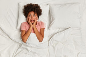 shutterstock 1347258575 Top,View,Of,Dark,Skinned,Woman,Scared,Of,Nightmare,,Lies