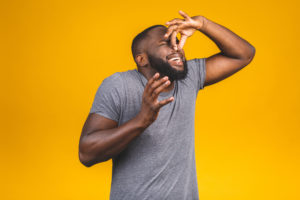 shutterstock 1422746594 Afro,American,Man,Isolated,Against,Yellow,Background,Smelling,Something,Stinky