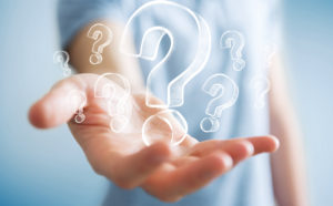 shutterstock 680112613 Businessman,On,Blurred,Background,Holding,Hand,Drawn,Question,Marks
