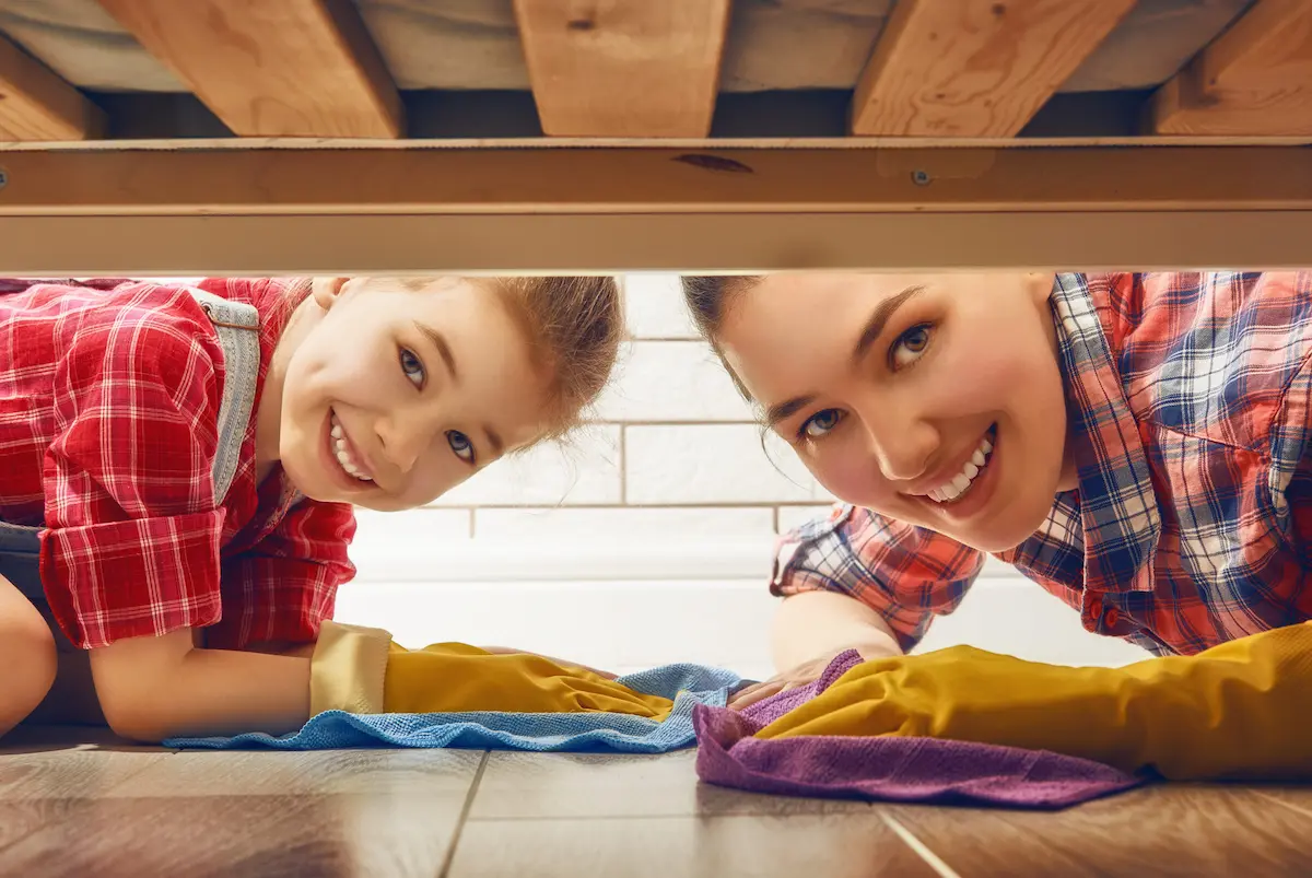 Mother and daughter cleaning the floor together at home