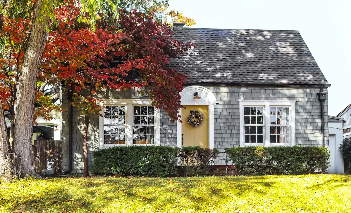 Suburban house exterior with autumn trees and front yard