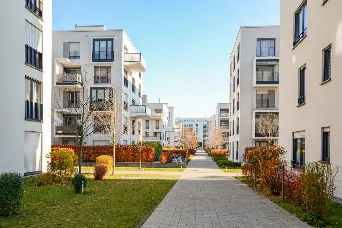 Modern apartment complex with landscaped walkway and residential buildings