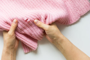 shutterstock 1530864476 Woman,Hands,Holding,The,Knitted,Thing,With,Hole,Made,By