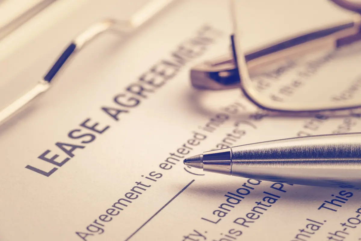 Close-up of a lease agreement with pen and glasses