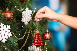shutterstock 161696162 Decorating,Christmas,Tree,On,Bright,Background