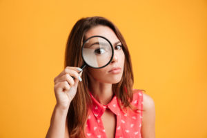 shutterstock 740624701 Close-up,Portrait,Of,Young,Serious,Woman,Looking,Through,A,Magnifying