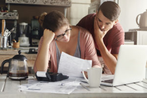 consequences money Young,Stressed,Caucasian,Couple,Facing,Financials,Troubles,,Sitting,At,Kitchen