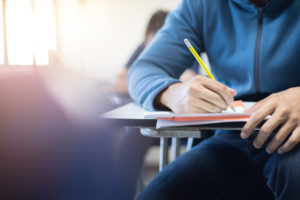 what if school spider Soft,Focus.high,School,Or,University,Student,Holding,Pencil,Writing,On