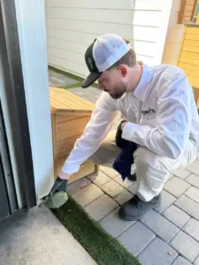Pointe Exterminator working on a house doorway